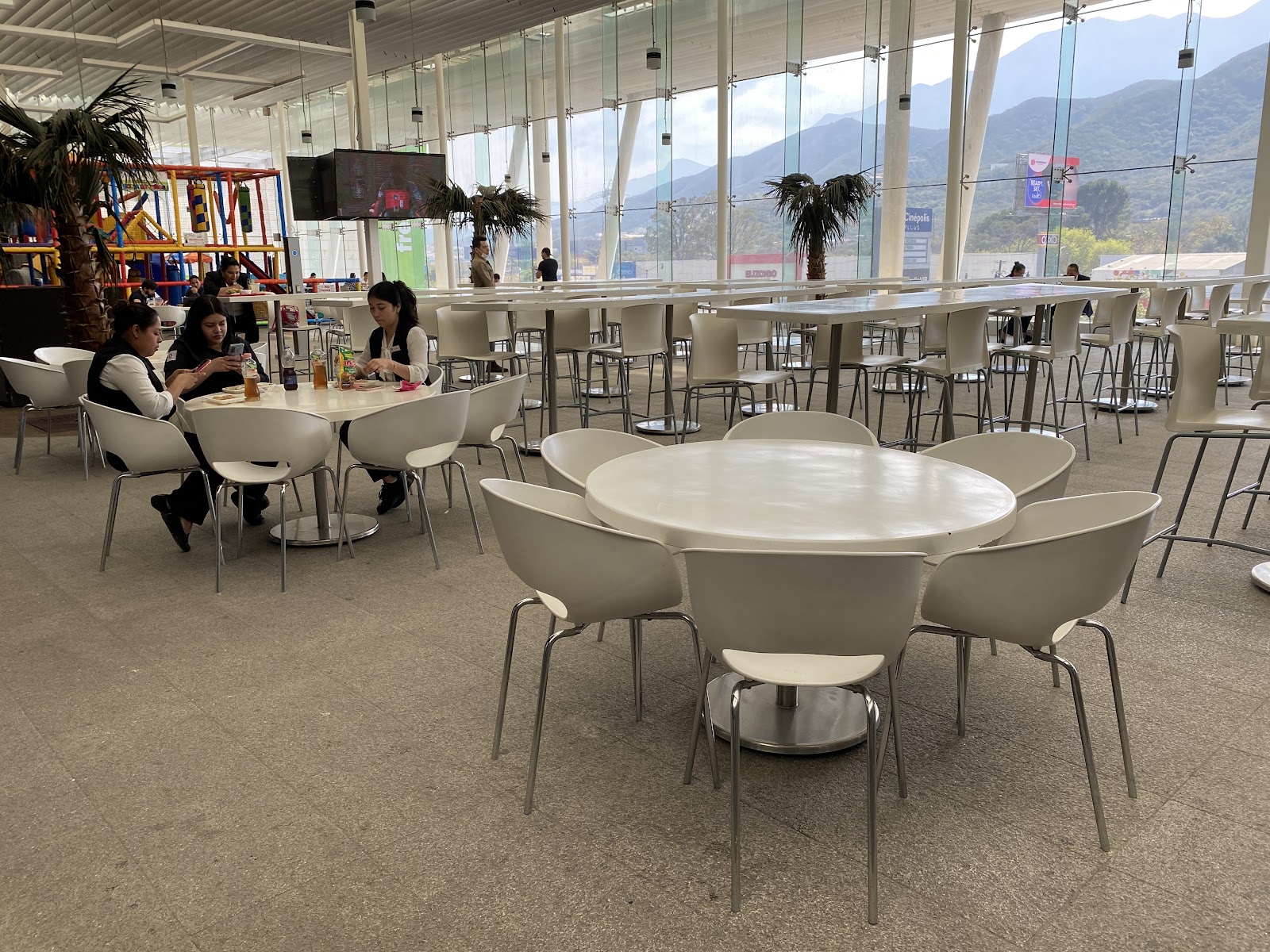 Food court de Esfera Monterrey con muros de cristal y vista a la montaña